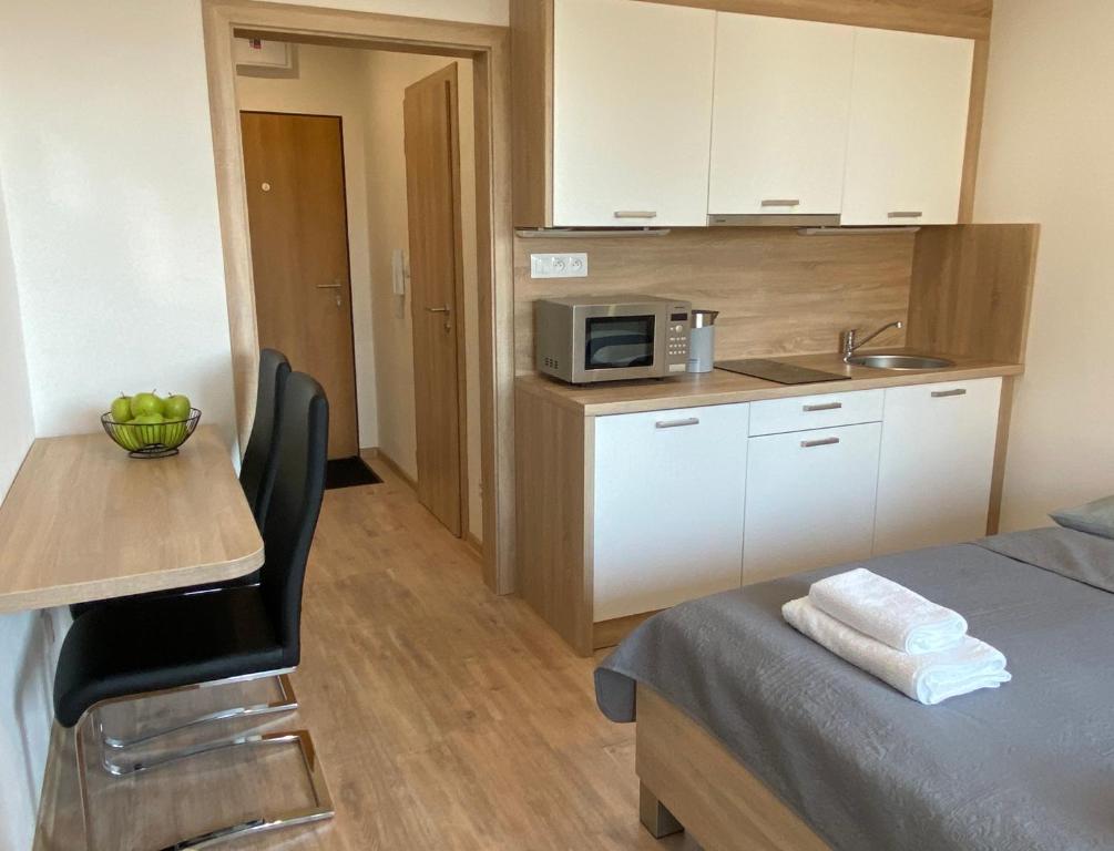uma cozinha com uma cama, uma mesa e um micro-ondas em Apartment Poprad em Poprad