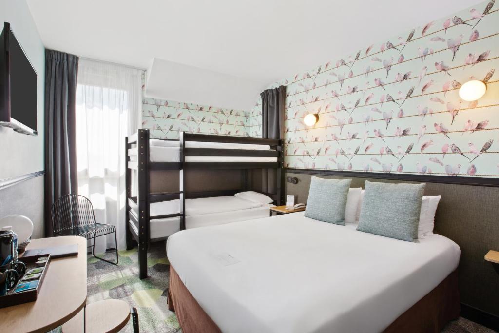 een slaapkamer met een bed en een stapelbed bij Best Western Hôtel Grand Parc Marne La Vallée in Chanteloup-en-Brie