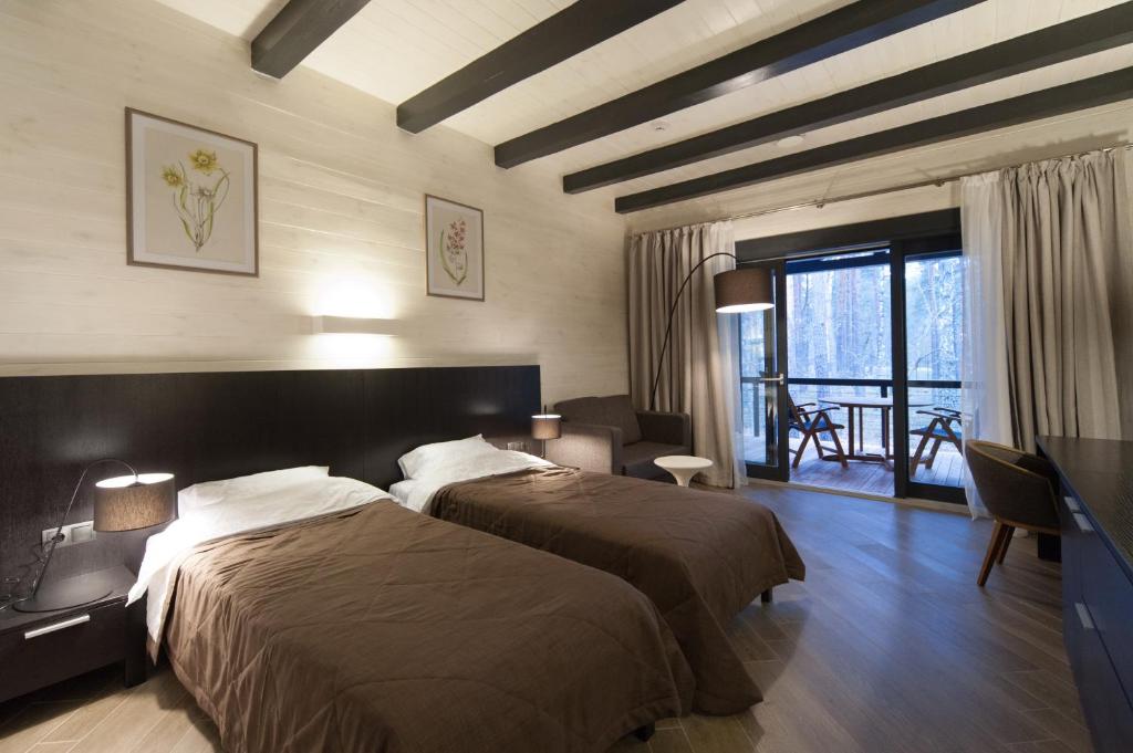 ein Hotelzimmer mit 2 Betten und einem Balkon in der Unterkunft Chalet Greenwood in Beloe Ozero