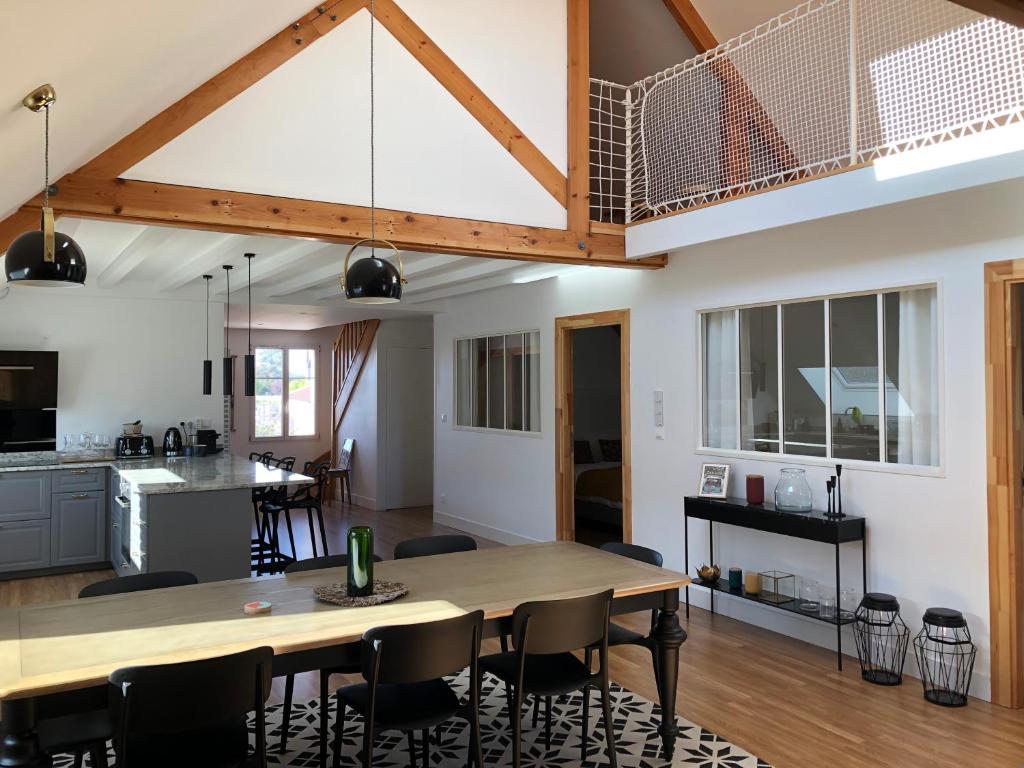 a kitchen and dining room with a large wooden table at Le Loft Deveney-Mars in Puligny-Montrachet