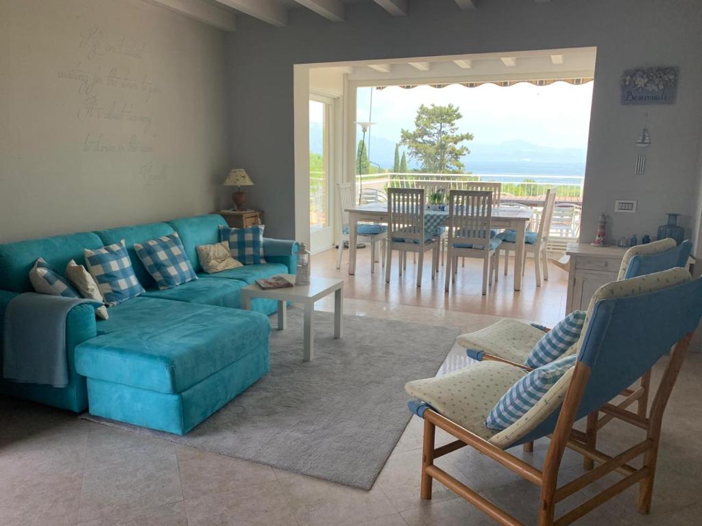 een woonkamer met een blauwe bank en een tafel bij Villa Elma in Lonato