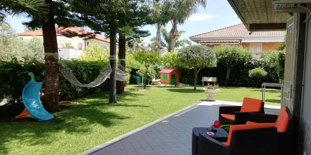 a patio with a swing and a yard at Casa Michelangela in Mascali