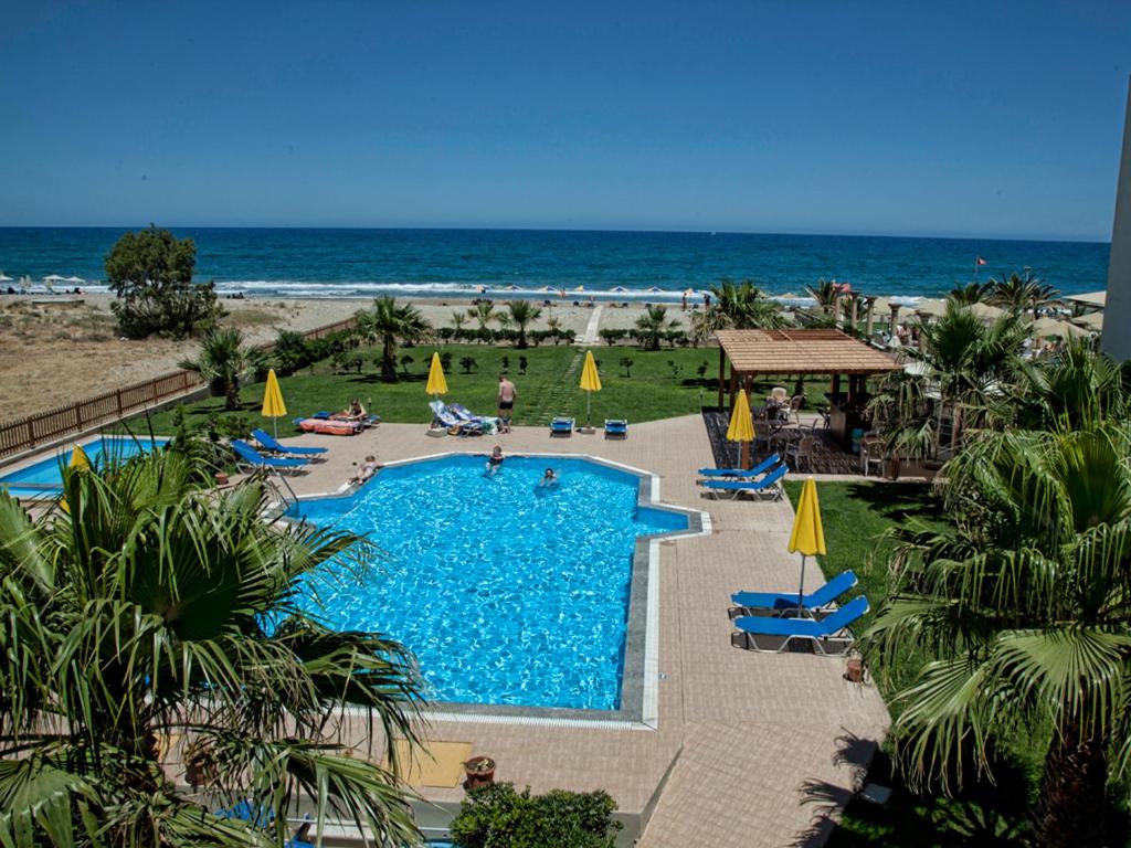 uitzicht op een zwembad en het strand bij Ilian Beach & Apartments in Rethimnon
