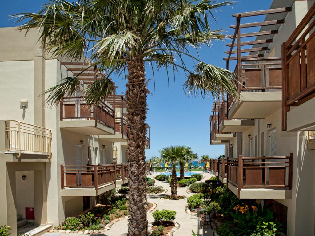 palma na dziedzińcu budynku z balkonami w obiekcie Ilian Beach & Apartments w Retimnie