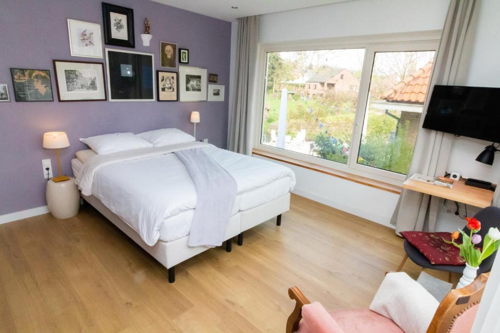 a bedroom with a white bed and a purple wall at Boutiquehotel B&B the SJinn in Schin op Geul