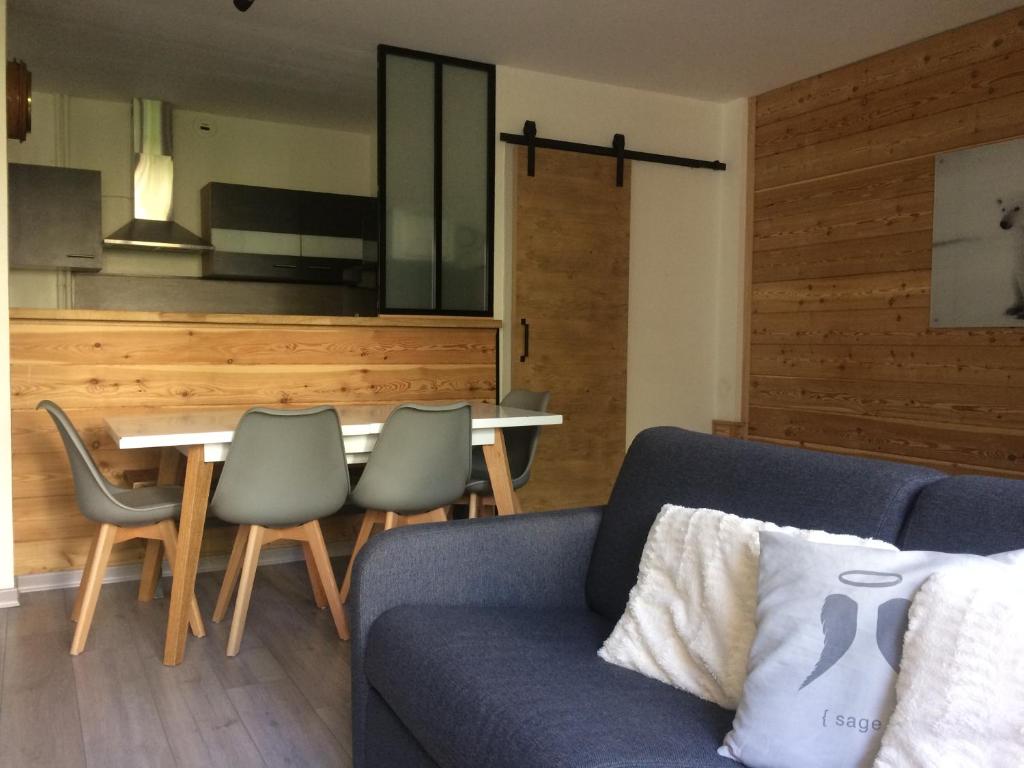 ein Wohnzimmer mit einem Sofa und einem Tisch in der Unterkunft Résidence du parc in Briançon