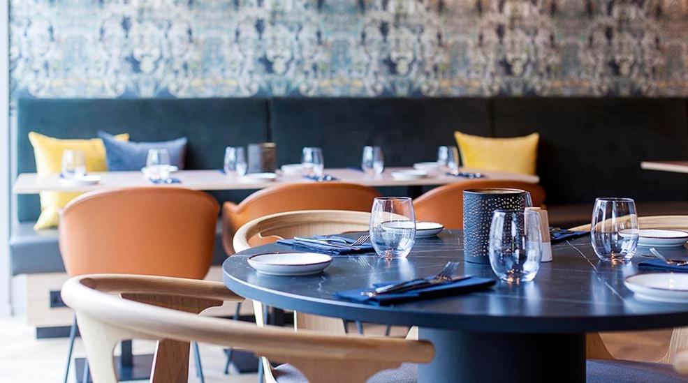 una sala da pranzo con tavolo, sedie e bicchieri di Comfort Hotel Victoria Florø a Florø