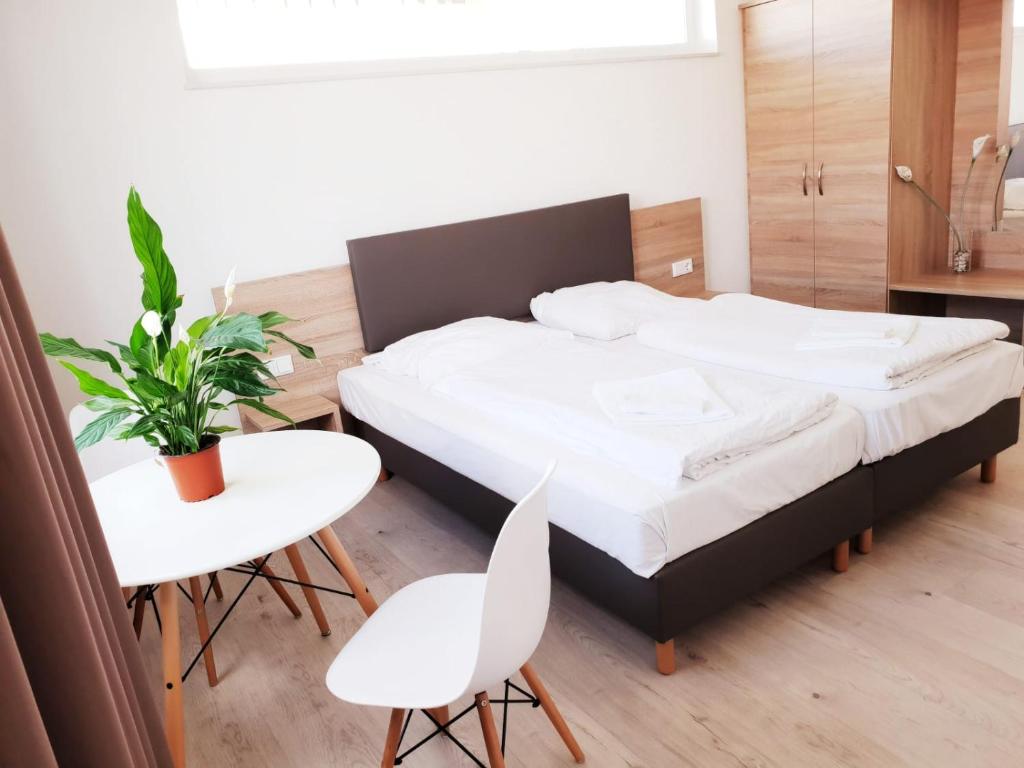 een slaapkamer met een bed en een tafel en stoelen bij Hotel Rodgau in Rodgau