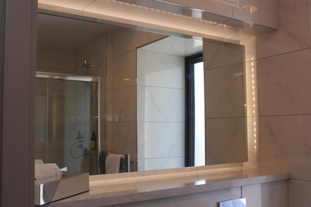 a mirror on a wall in a bathroom at Baginbun Lodge in Fethard on Sea