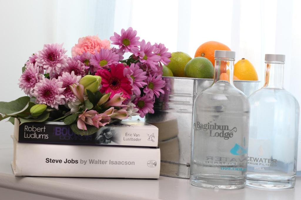 a bottle of water and flowers on a table with a bottle at Baginbun Lodge in Fethard on Sea