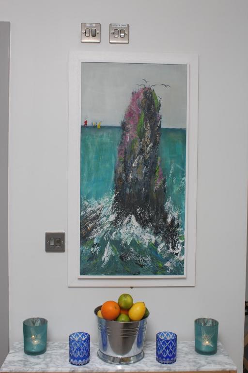 a painting hanging on a wall with a bowl of fruit at Baginbun Lodge in Fethard on Sea