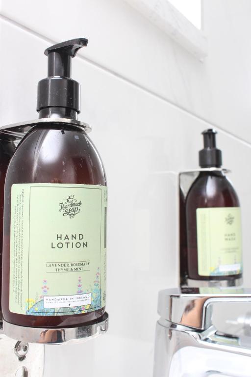 two bottles of hair lotion sitting on a sink at Baginbun Lodge in Fethard on Sea