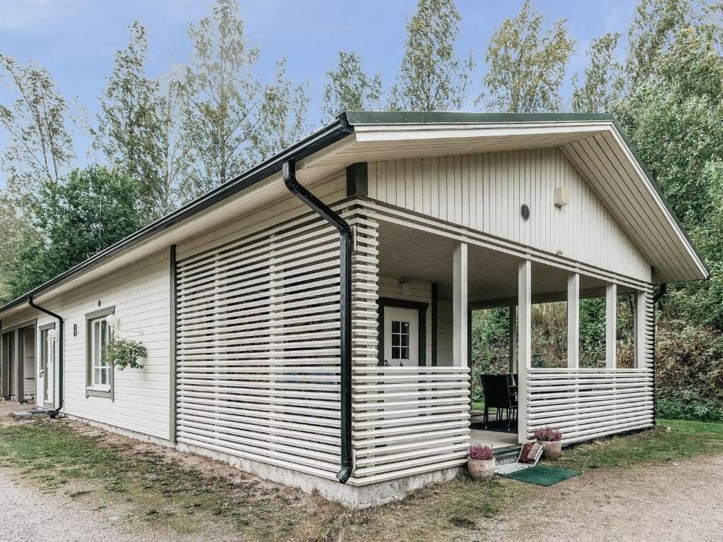 ein kleines weißes Haus mit einer großen Veranda in der Unterkunft Holiday Home B by Interhome in Porvoo