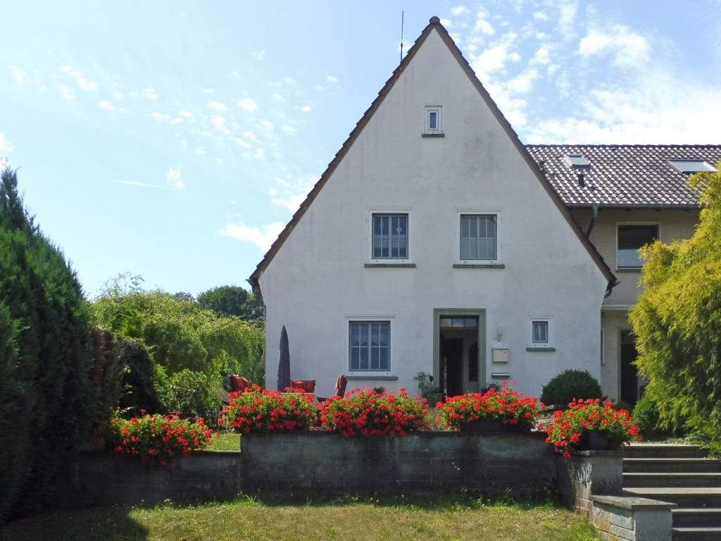 a white house with flowers in front of it at Holiday Home Haus am Berg der Osterräder by Interhome in Lügde