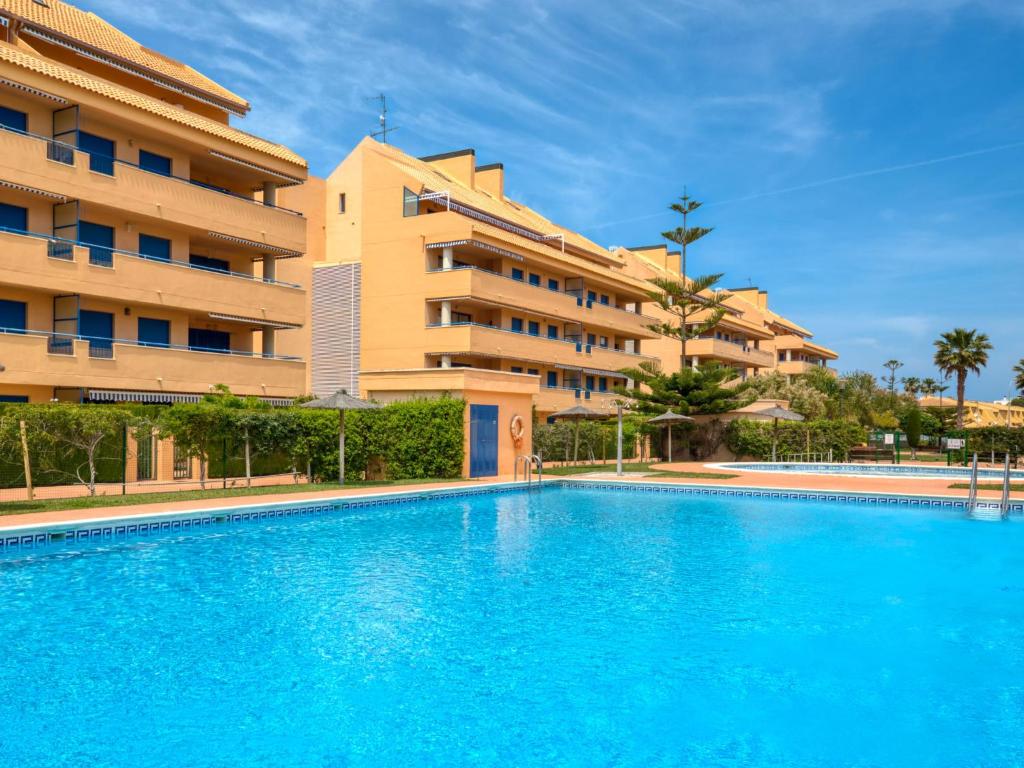 a swimming pool in front of a building at Apartment La Marjal-3 by Interhome in Denia