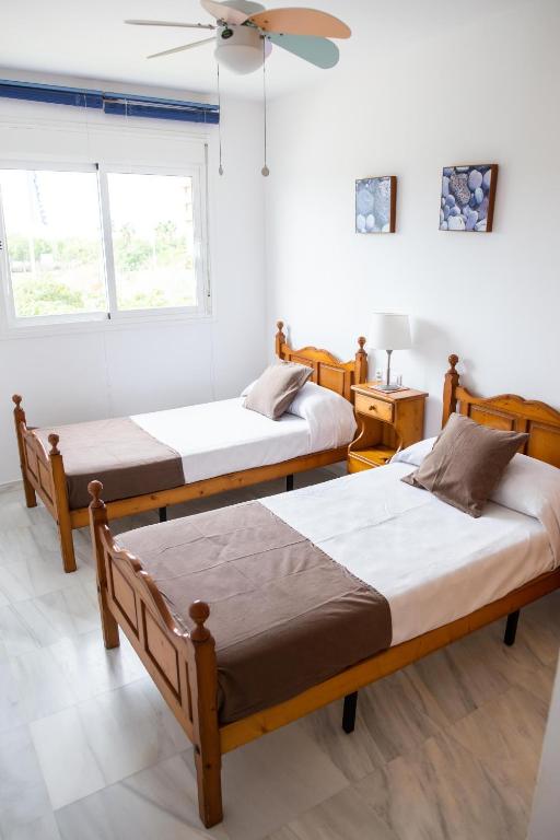Pokój z 3 łóżkami i wentylatorem sufitowym w obiekcie Piso encantador junto al mar, relax, tranquilidad w mieście Torre del Mar