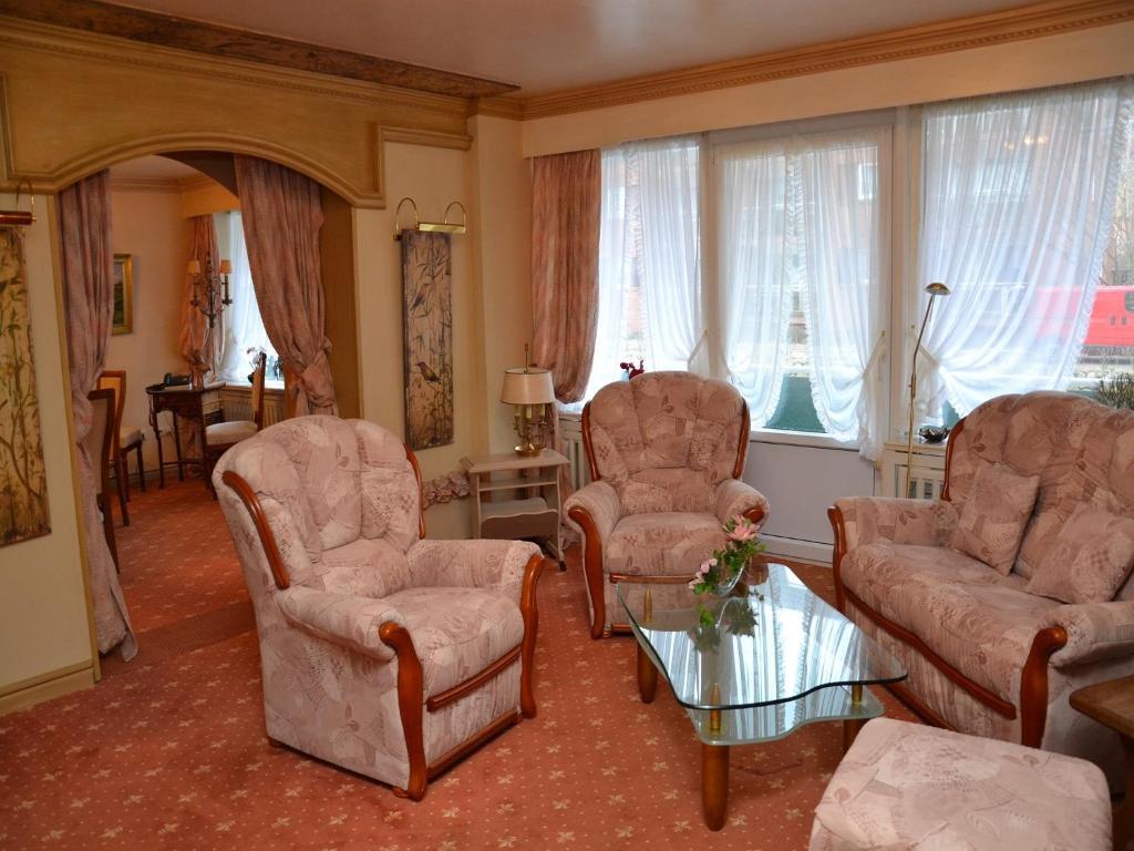 a living room with chairs and a couch and a table at Haus Schaper in Westerland