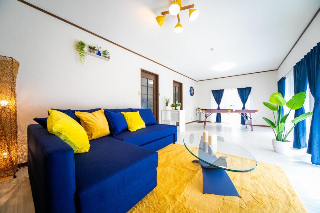 um sofá azul com almofadas amarelas numa sala de estar em Yokkaichi Large House in Shimizucho nearby Yokkaichi STN em Yokkaichi