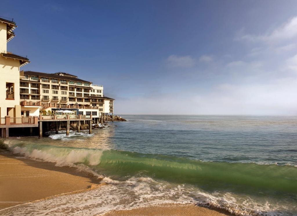 Blick auf das Meer und einen Strand mit Gebäuden in der Unterkunft Monterey Plaza Hotel & Spa in Monterey