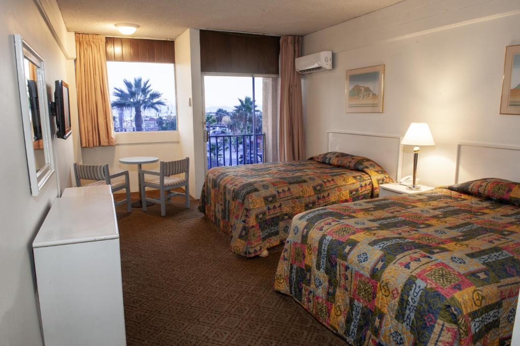 a hotel room with two beds and a table at Hotel Villa Marina in Ensenada