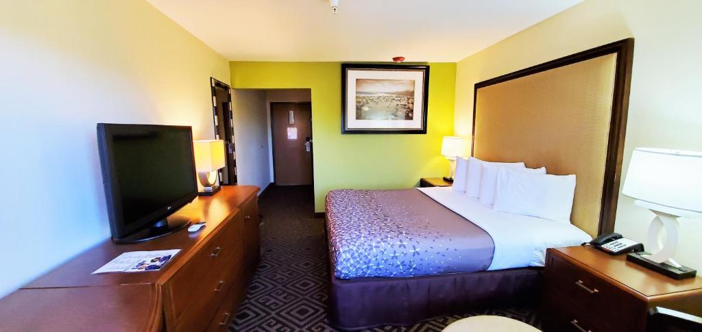 a hotel room with a bed and a flat screen tv at Travel Inn and Suites in Sikeston