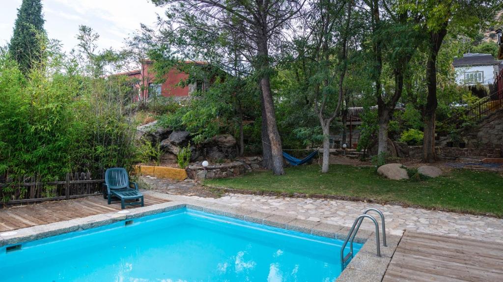 una piscina en el patio trasero de una casa en Casita en La Sierra, en Zarzalejo