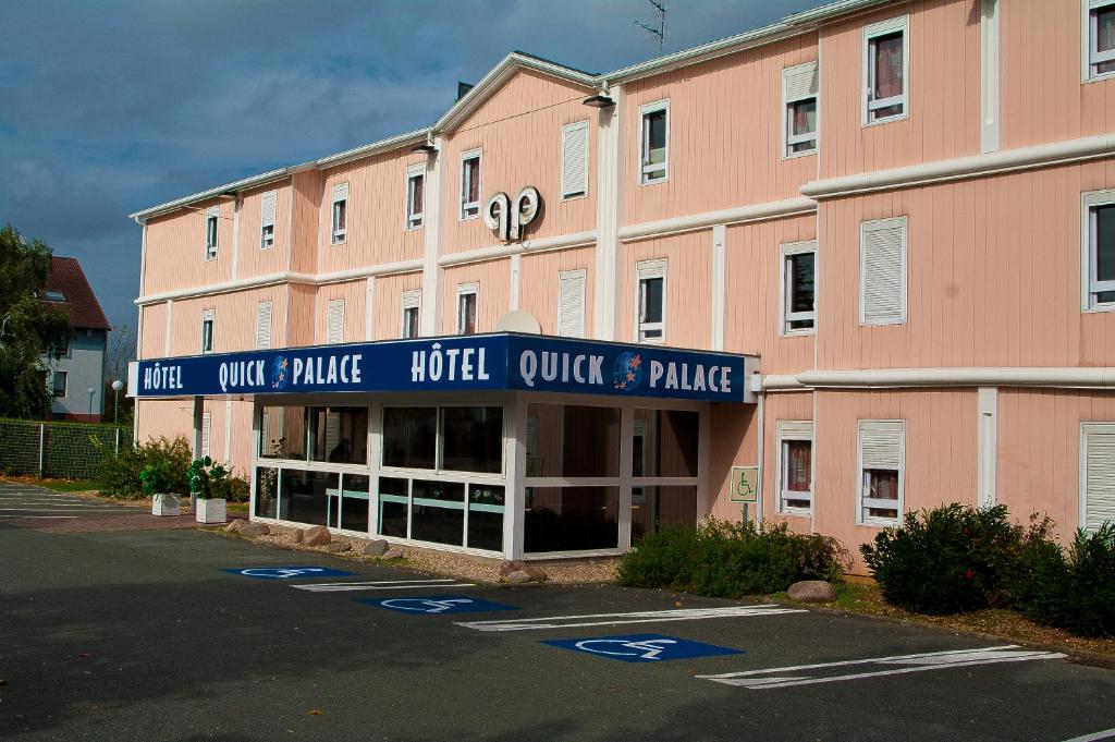un gran edificio rosa con un cartel para un hotel en Quick Palace Poitiers, en Chasseneuil-du-Poitou