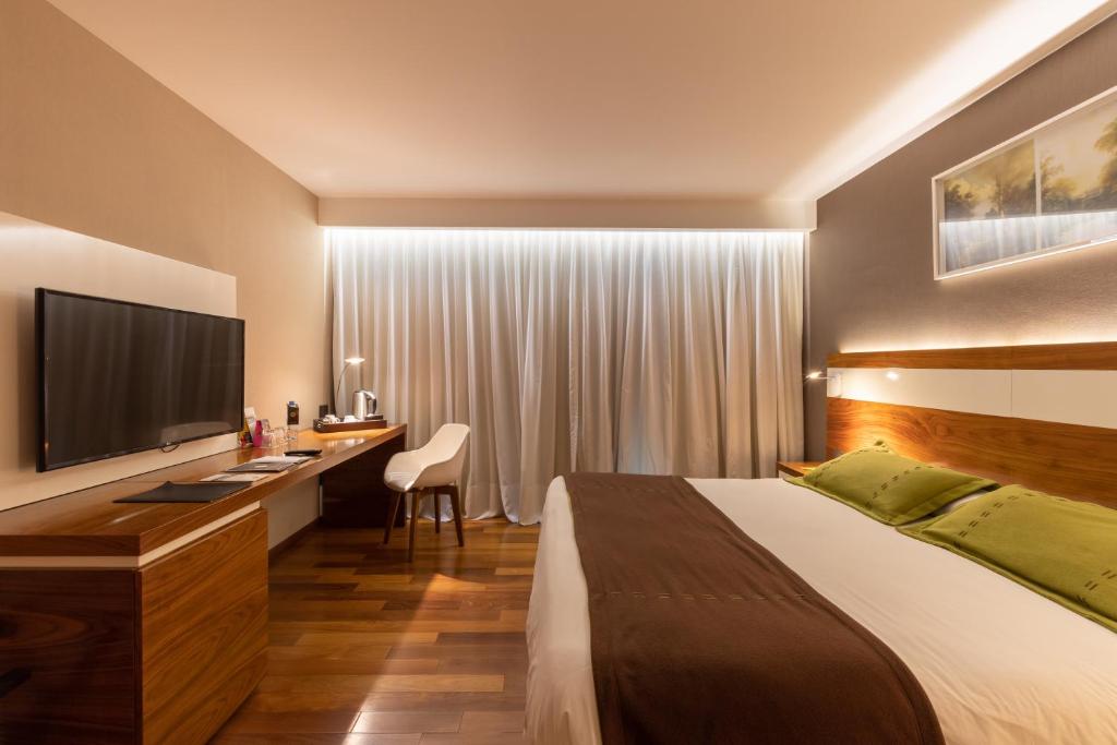 
a bedroom with a bed and a television at Yrigoyen 111 Hotel in Córdoba
