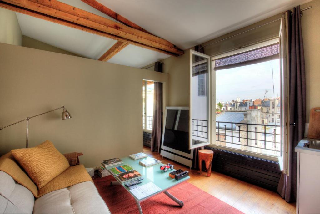 a living room with a couch and a table at Atelier dernier étage bail mobilité Louvre in Paris