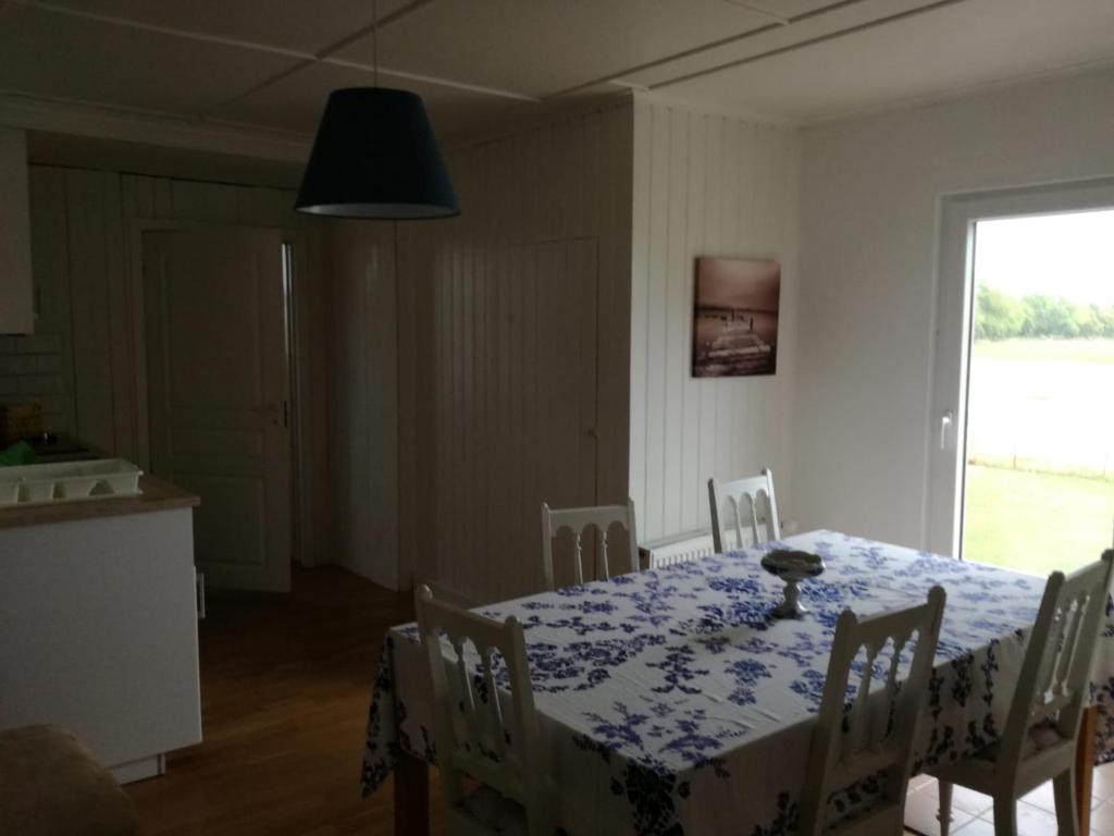 a dining room with a table with a blue and white table cloth at Manus Ferienwohnung in Brevik