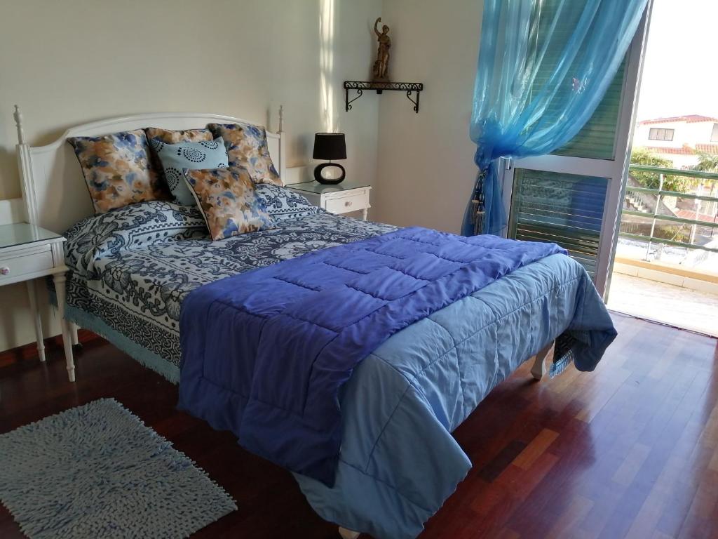 フンシャルにあるApartamentos Jardimのベッドルーム1室(青い掛け布団付)