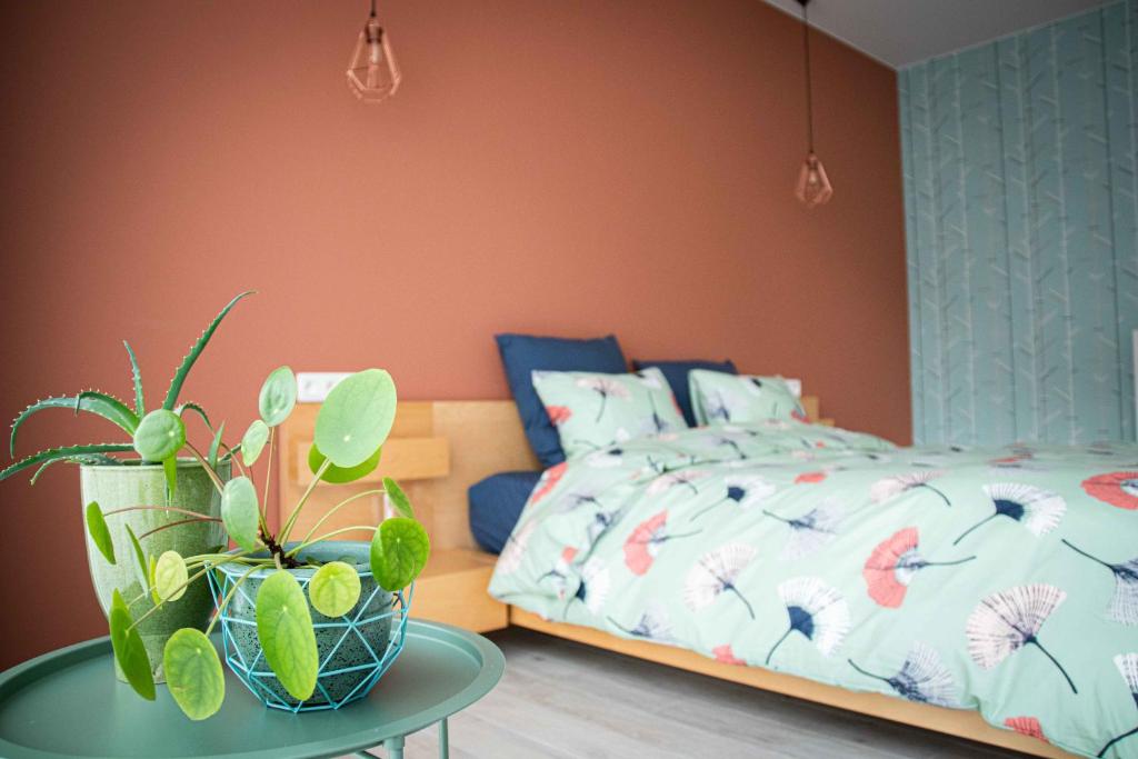 a bedroom with a bed and a table with a potted plant at Barbos in Lembeke