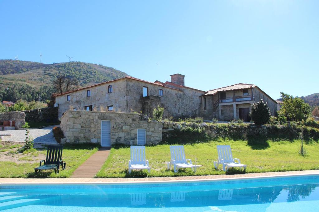 una casa con 2 sillas de césped y una piscina en Casa Da Gaiteira, en Vieira do Minho