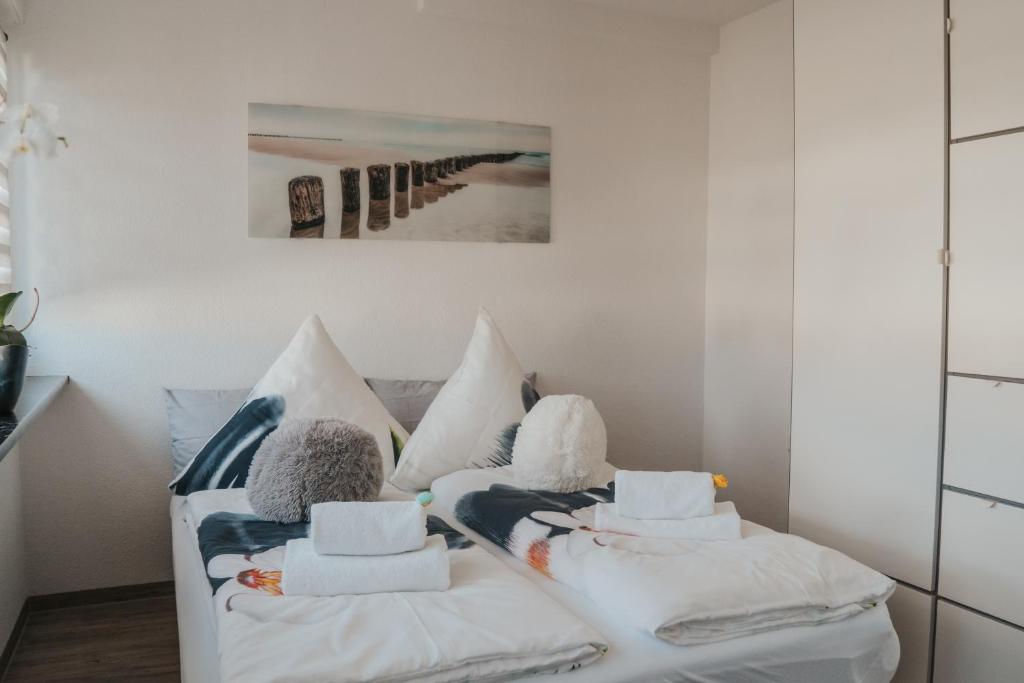 a living room with a white couch with pillows at Residenz Fischbach KIBA in Friedrichshafen