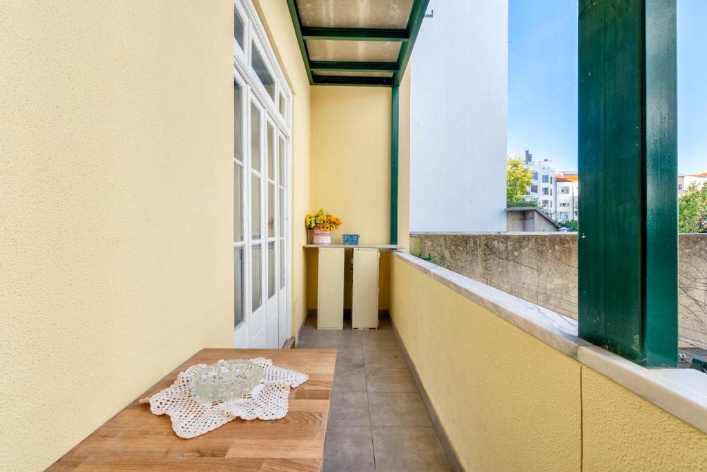 uma varanda com uma mesa e uma janela em Donapart em Lisboa