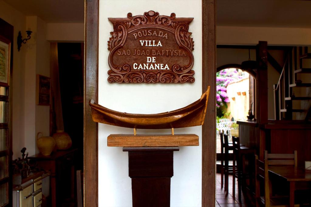 un cartello per un ristorante su un muro in una stanza di Pousada Villa de Cananea a Cananéia