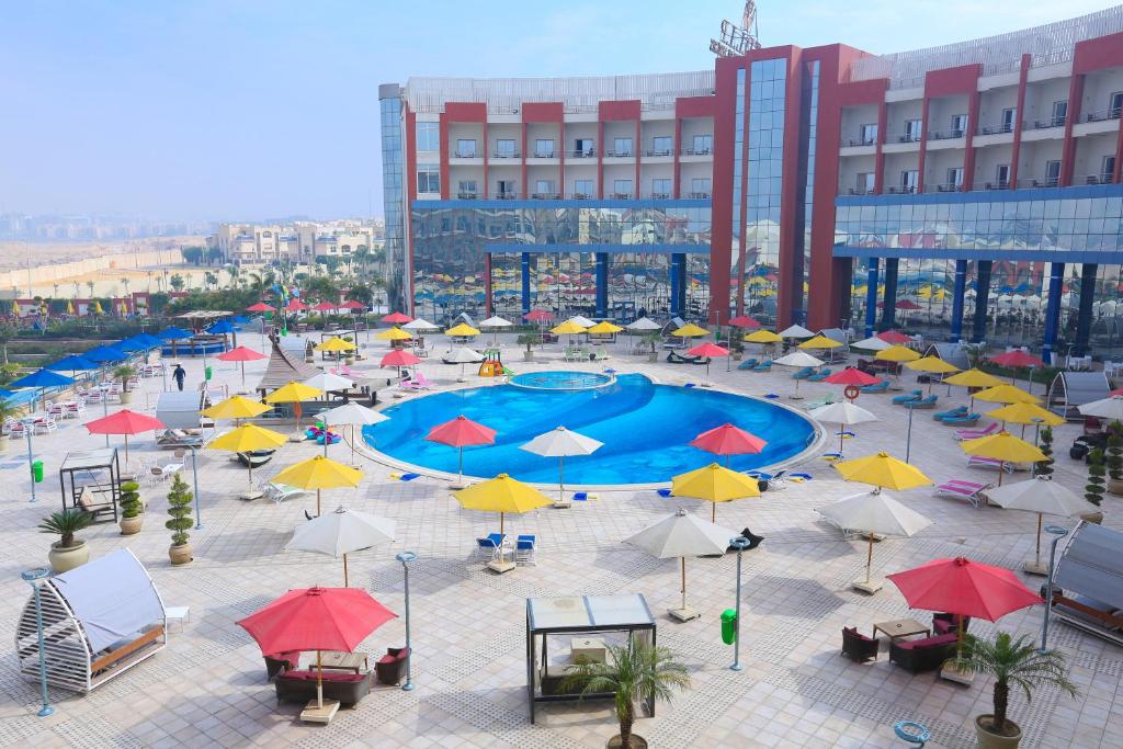 a courtyard with a pool with umbrellas and tables at Tolip El Narges in Cairo