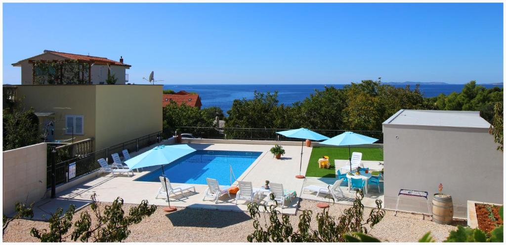 - une piscine avec des chaises et des parasols sur une maison dans l'établissement Apartment Katarina and house Marieta, à Dolac