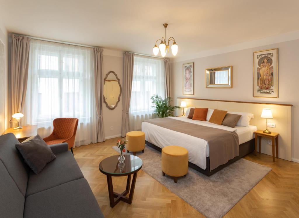 プラハにあるSeNo6 Apartmentsのベッドとソファ付きのホテルルーム