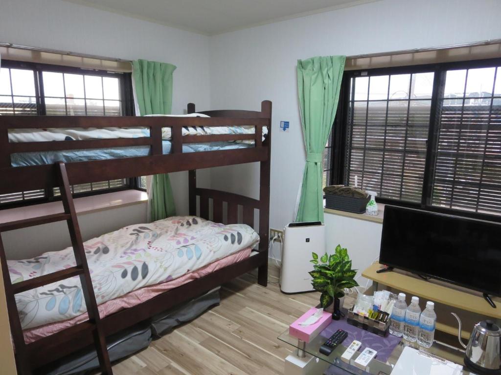 1 Schlafzimmer mit 2 Etagenbetten und einem TV in der Unterkunft Stay Snnabe / Vacation STAY 52638 in Kumamoto