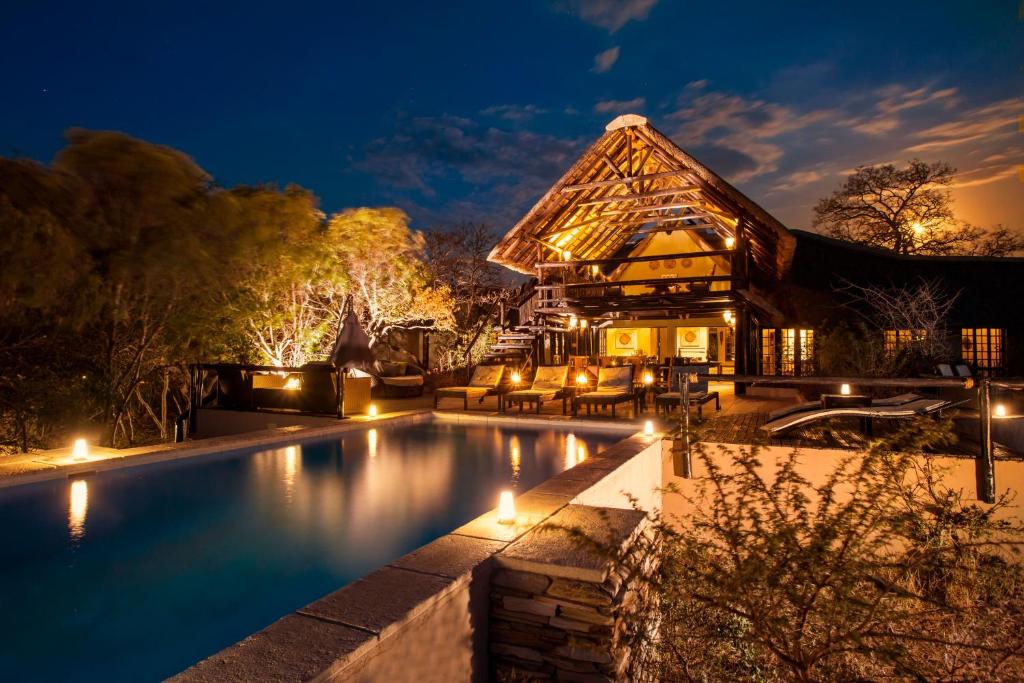 an image of a house with a swimming pool at night at Vuyani Safari Lodge in Hoedspruit