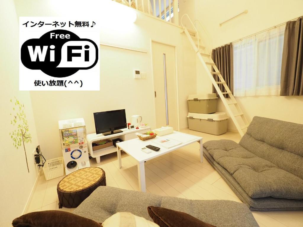 ein Wohnzimmer mit einem Sofa und einem Tisch in der Unterkunft i home Tsubogawa / Vacation STAY 53028 in Naha