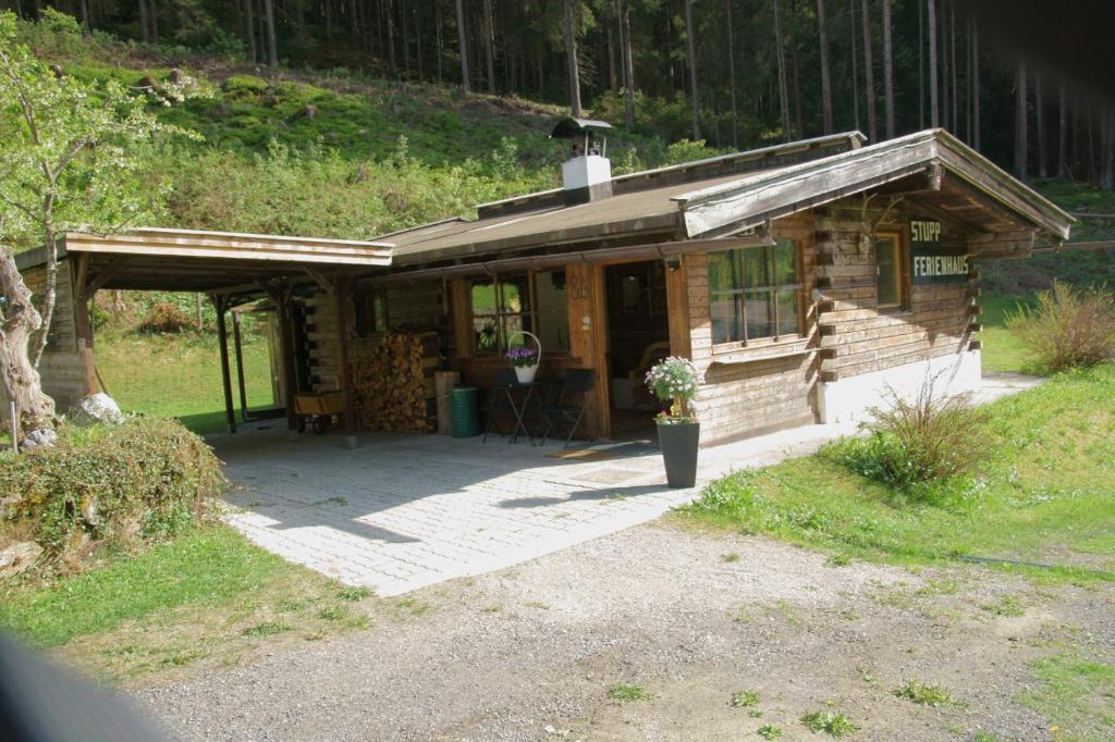 eine kleine Holzhütte auf einem Feld mit einer Veranda in der Unterkunft Ferienhaus Stupp in Gries im Sellrain