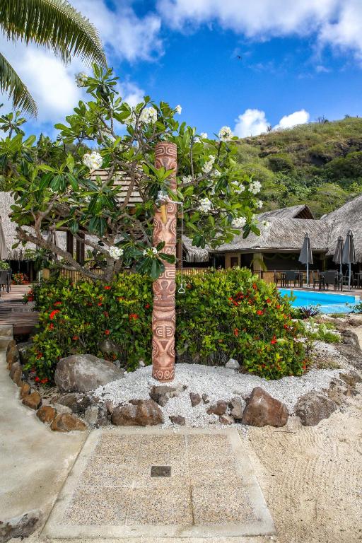 a tree in a garden next to a resort at ROYAL BORA BORA in Bora Bora