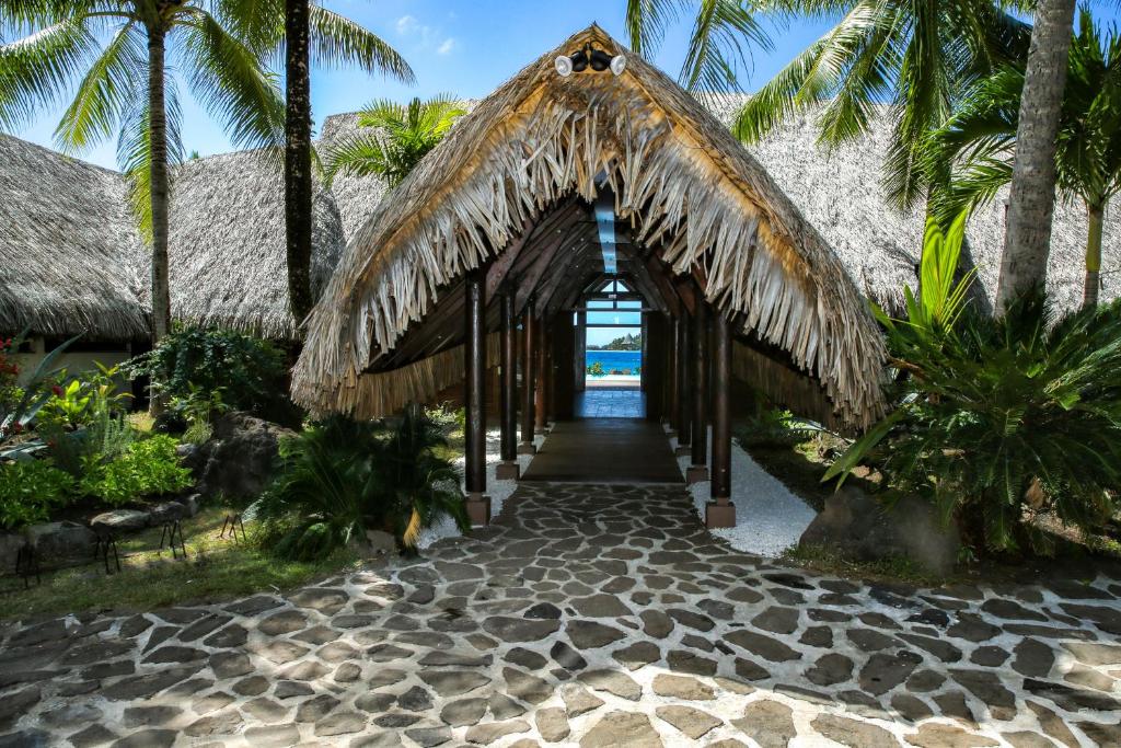 a pathway leading to a resort with palm trees at ROYAL BORA BORA in Bora Bora