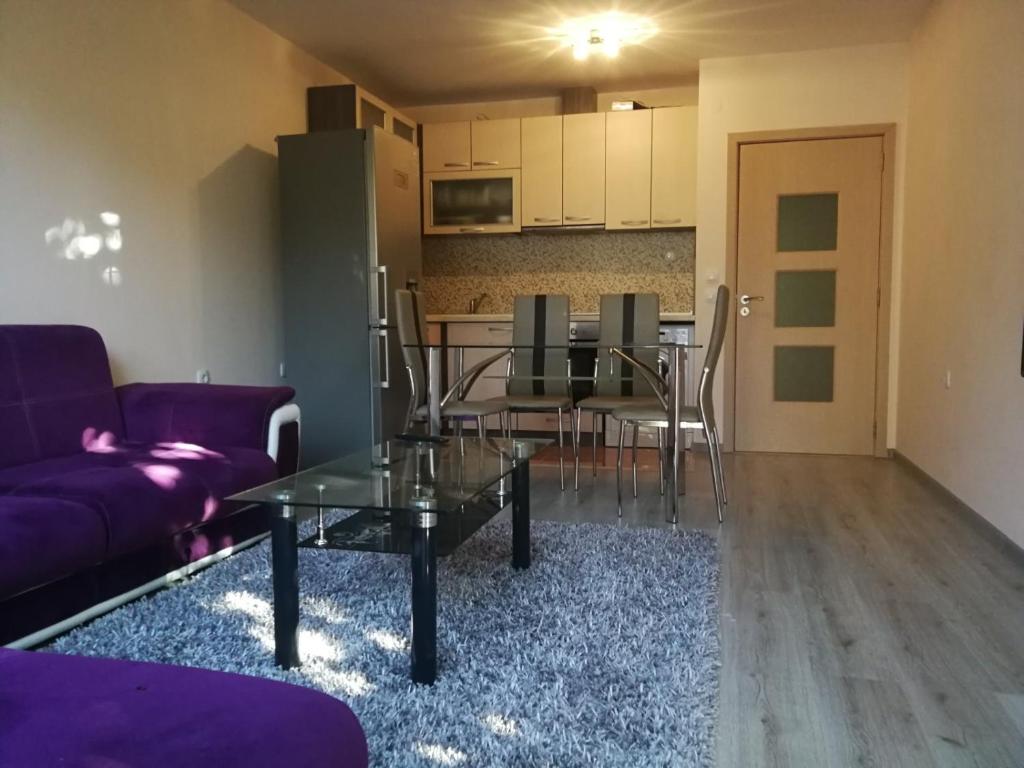 サンダンスキにあるЛуксозен апартамент в идеалния център на град Санданскиの紫色のソファとテーブルのあるリビングルーム