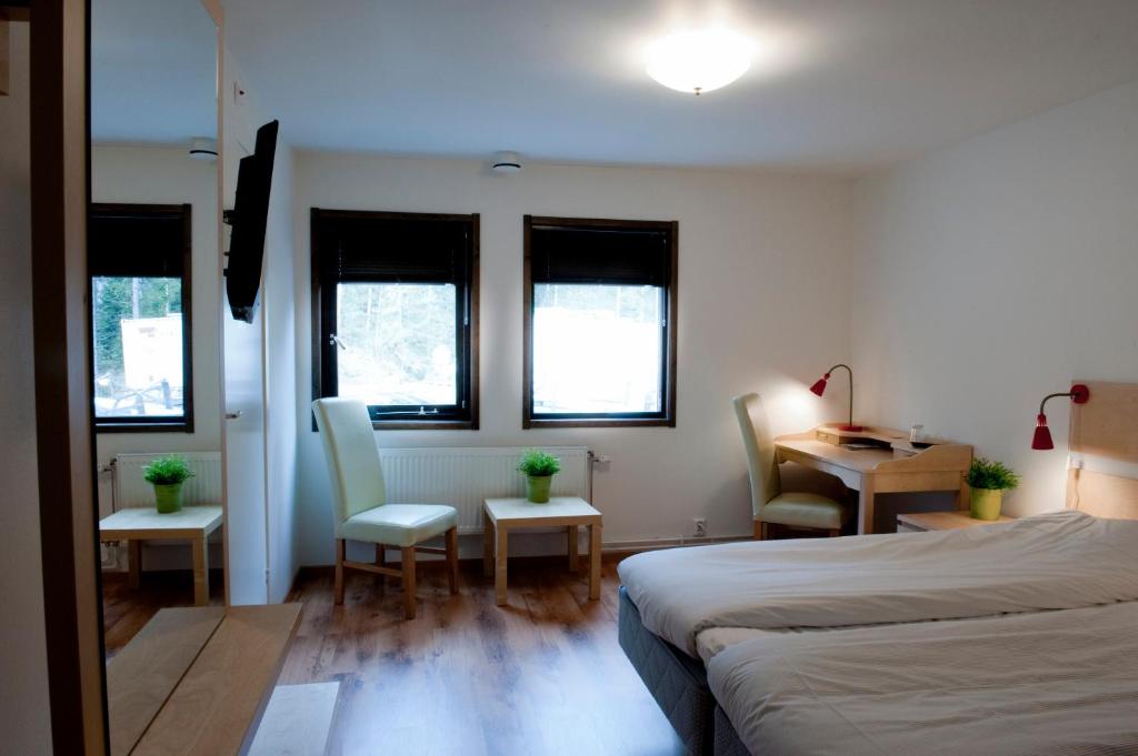 een slaapkamer met een bed en een tafel en stoelen bij STF Valbergsängen Sporthotell in Torsby