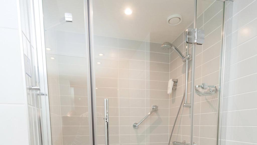 a bathroom with a shower with a glass door at Holiday Inn Express Aberdeen Airport by IHG in Dyce