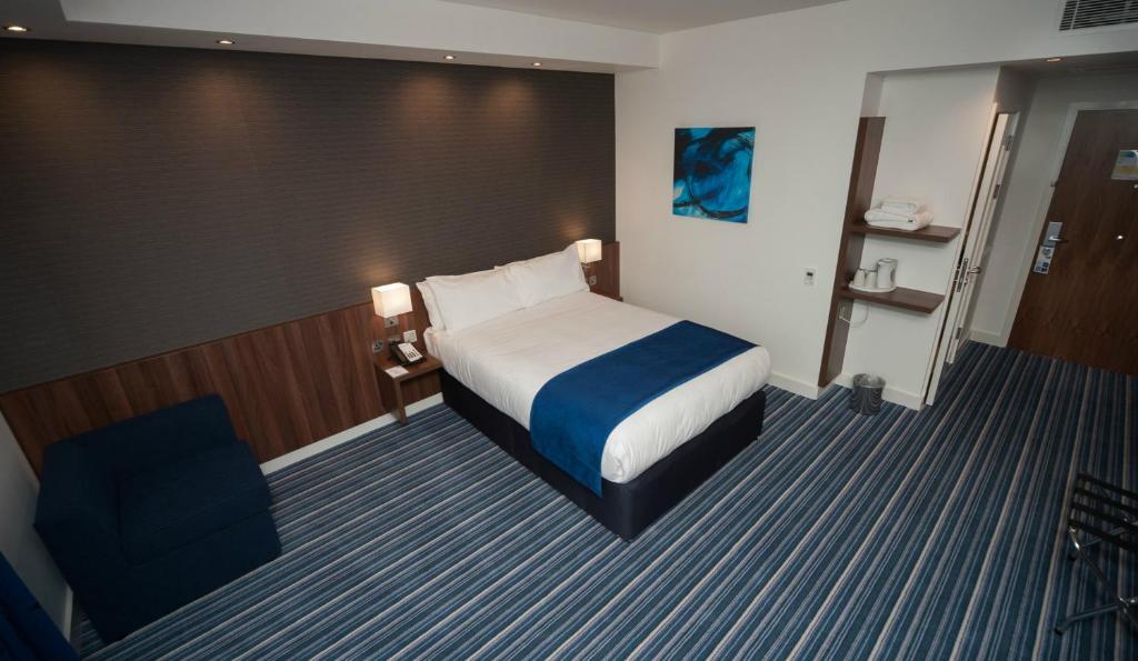a hotel room with a bed and a chair at Holiday Inn Express Aberdeen Airport by IHG in Dyce