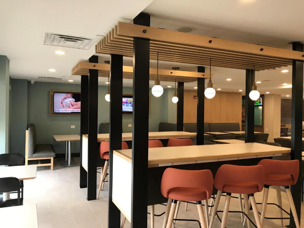 a restaurant with a bar with orange chairs at Holiday Inn Allentown-Bethlehem by IHG in Allentown